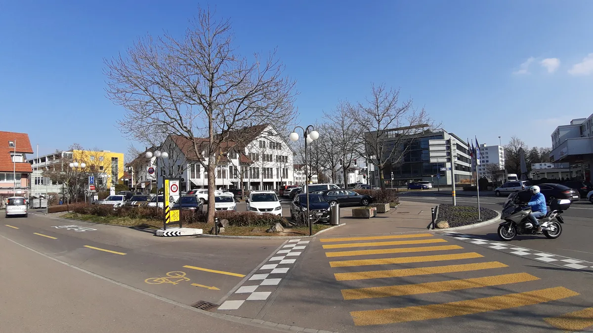 Blick auf einen Parkplatz, der von Strassen umgeben ist. 
